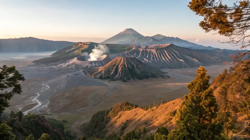 Panoramic sunrise view of Mount Bromo and the Tengger volcanic landscape, showcasing one of the best treks in Indonesia with dramatic craters, rugged valleys, and scenic mountain trails.